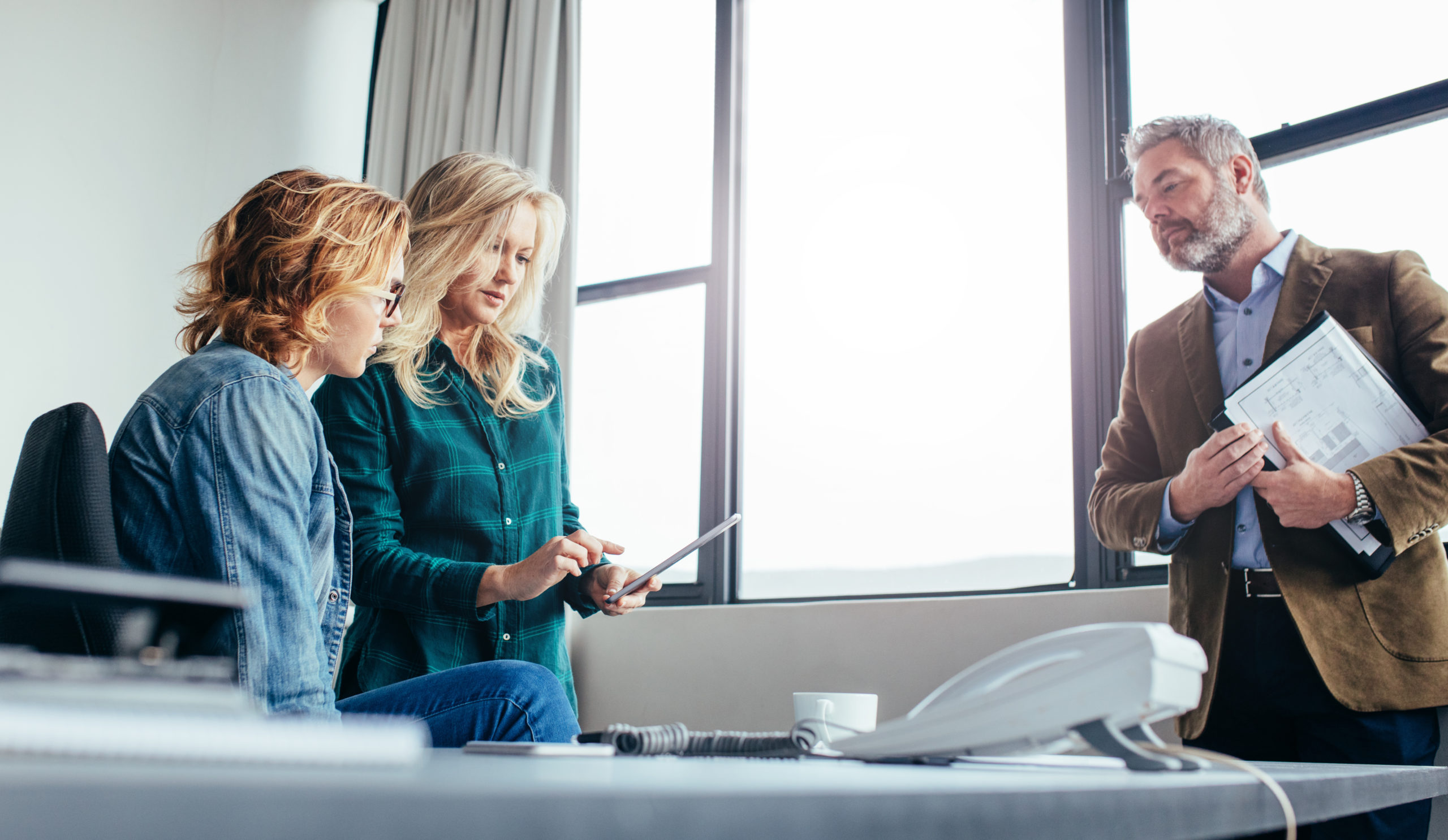 Business,Woman,Explaining,Something,To,Female,Coworker,With,A,Digital